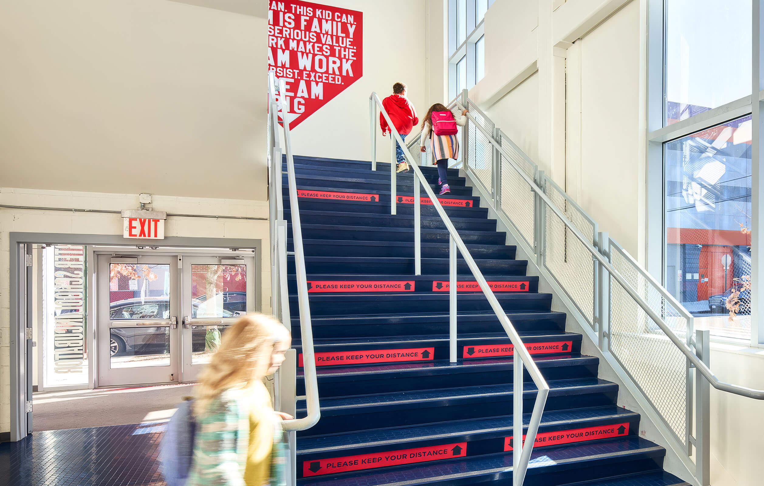 People walking up the light-filled stairs at the Neighborhood Charter School in the Bronx