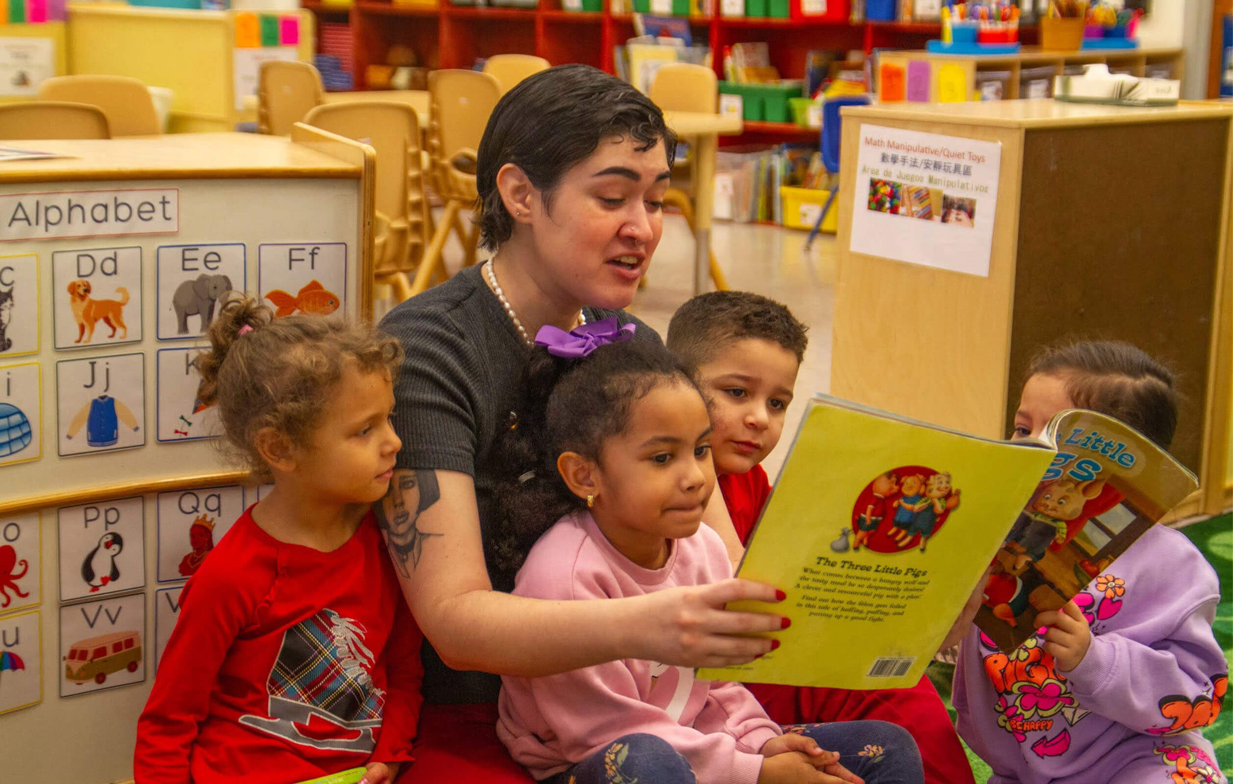 A teacher reading to students at a Grand Street Settlement daycare center