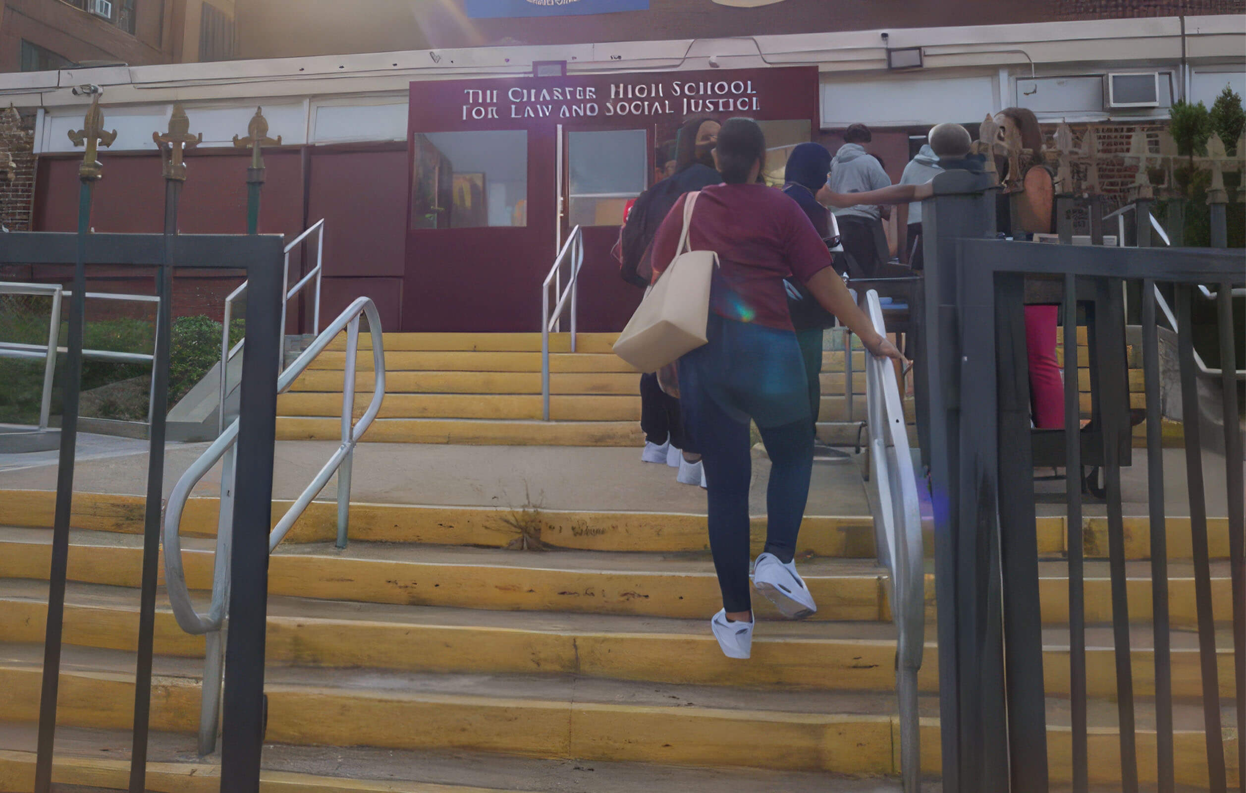 Students walking up the stairs at the entrance to the Charter High School for Law & Social Justice in the Bronx
