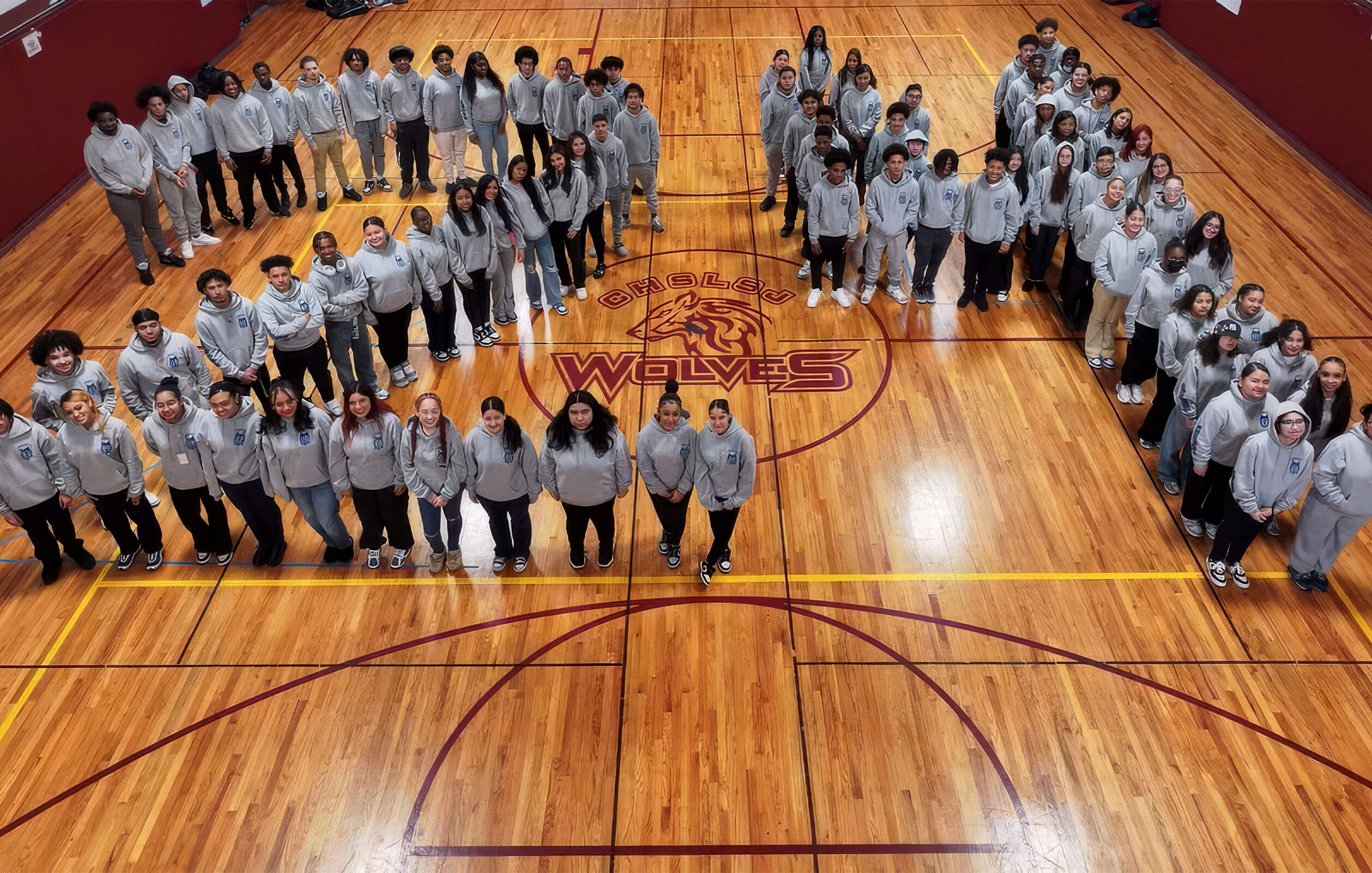 Students of the class of 2024 of the Charter High School for Law and Social Justice lining up on the gym floor to form the number 24