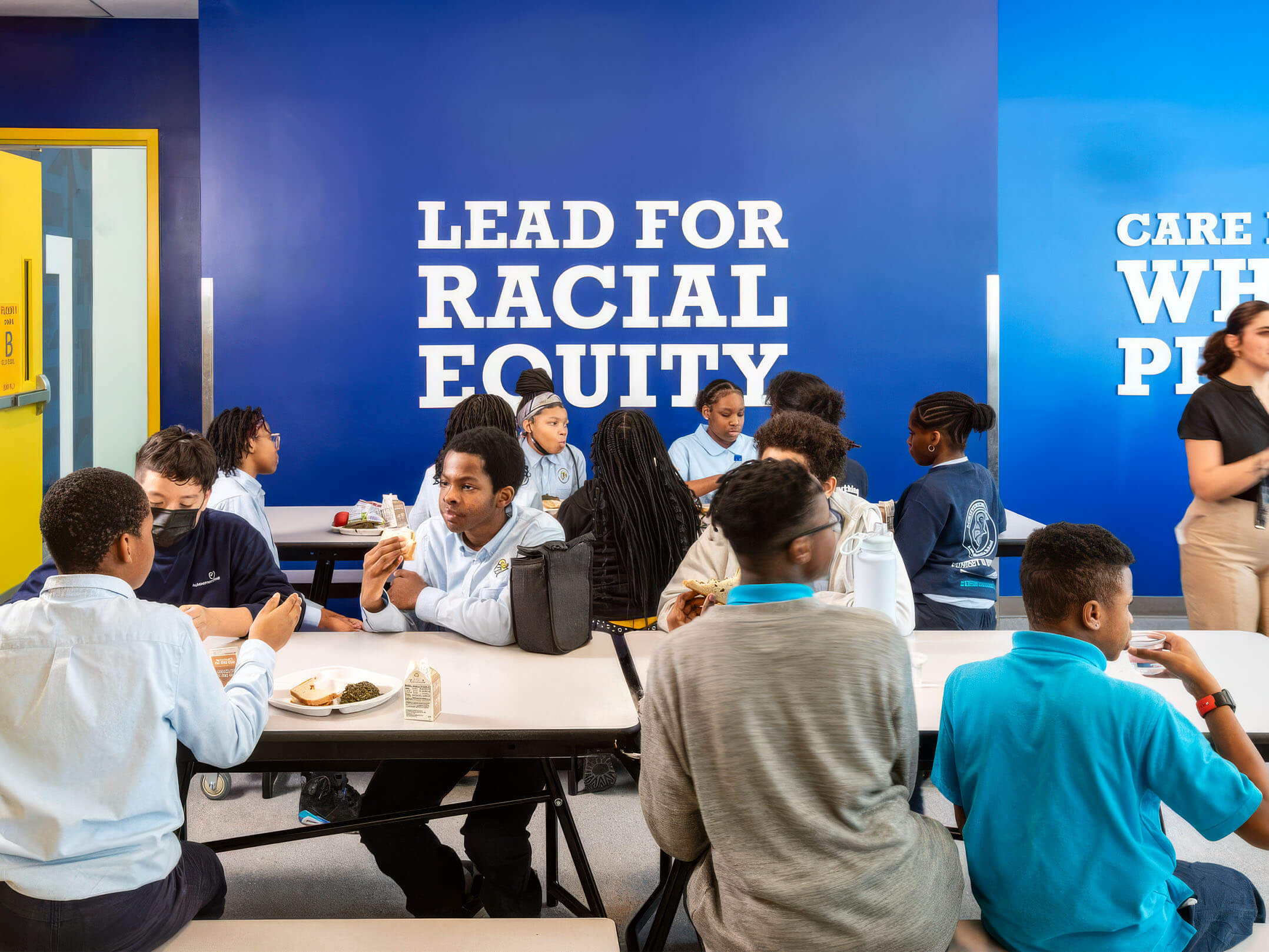 Students eating lunch next to signage at the Linden Middle School