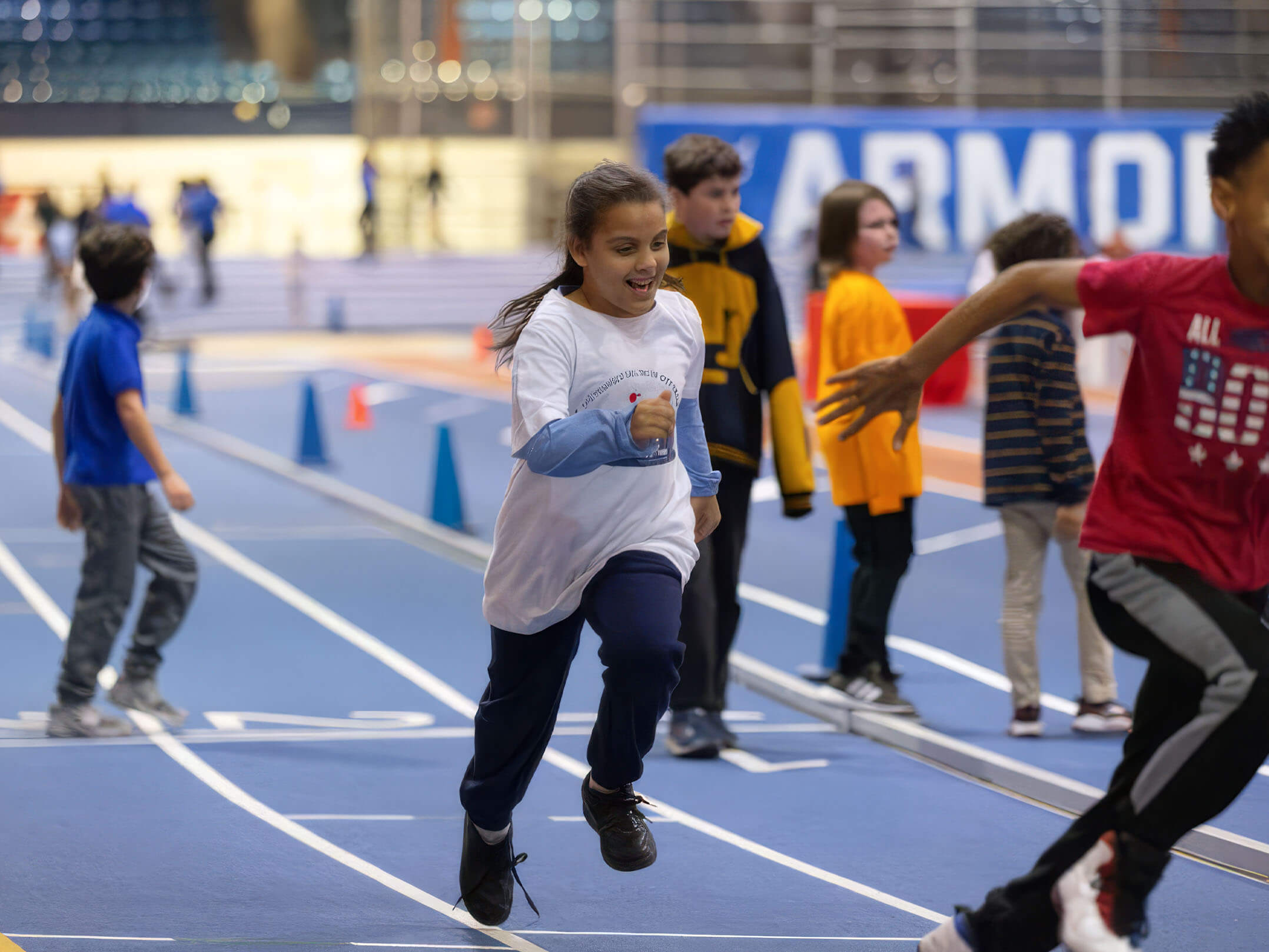 Kids running on the track at the Nike Track & Field Center at the Armory
