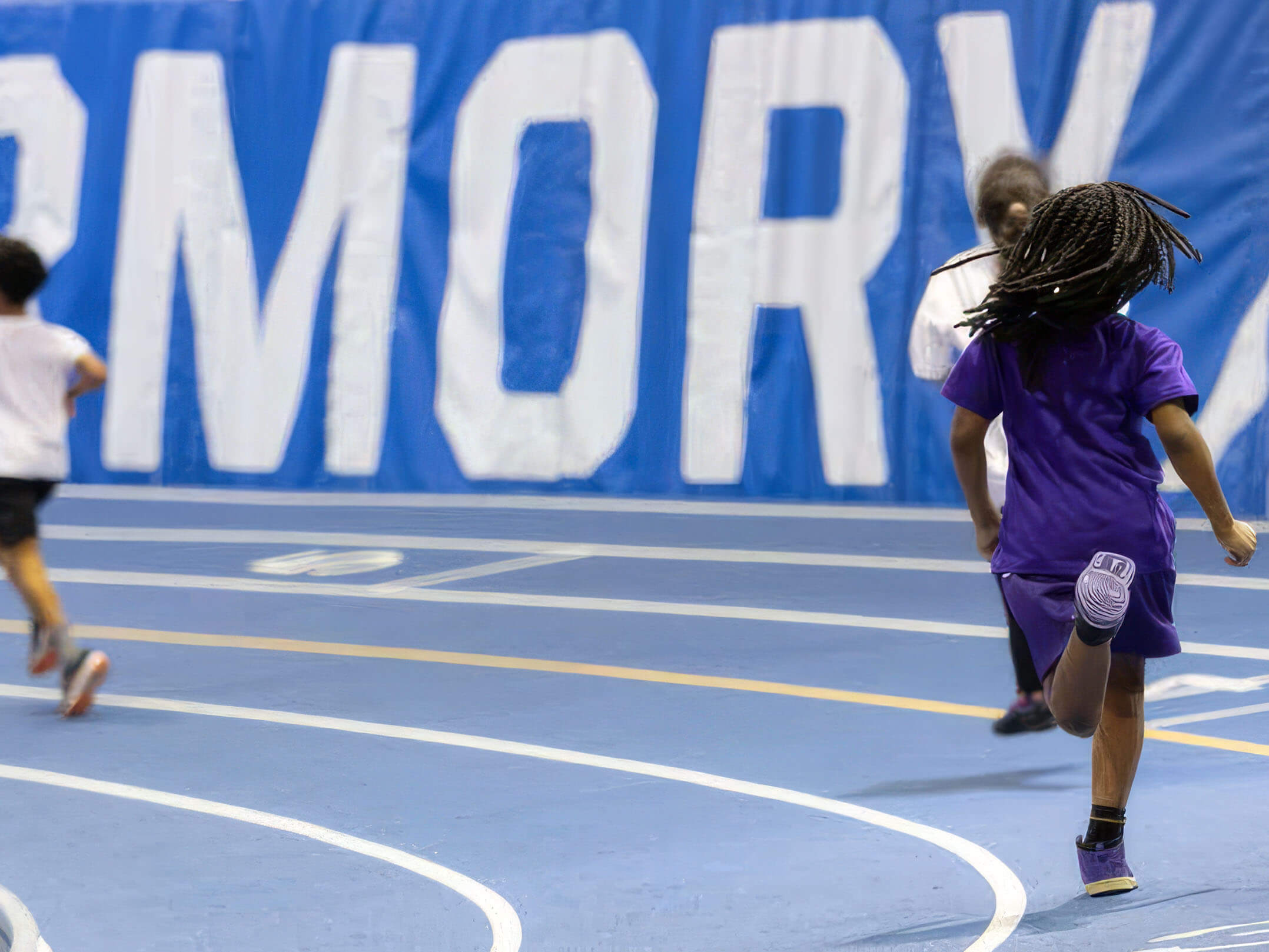 Kids running on the track at the Nike Track & Field Center at the Armory