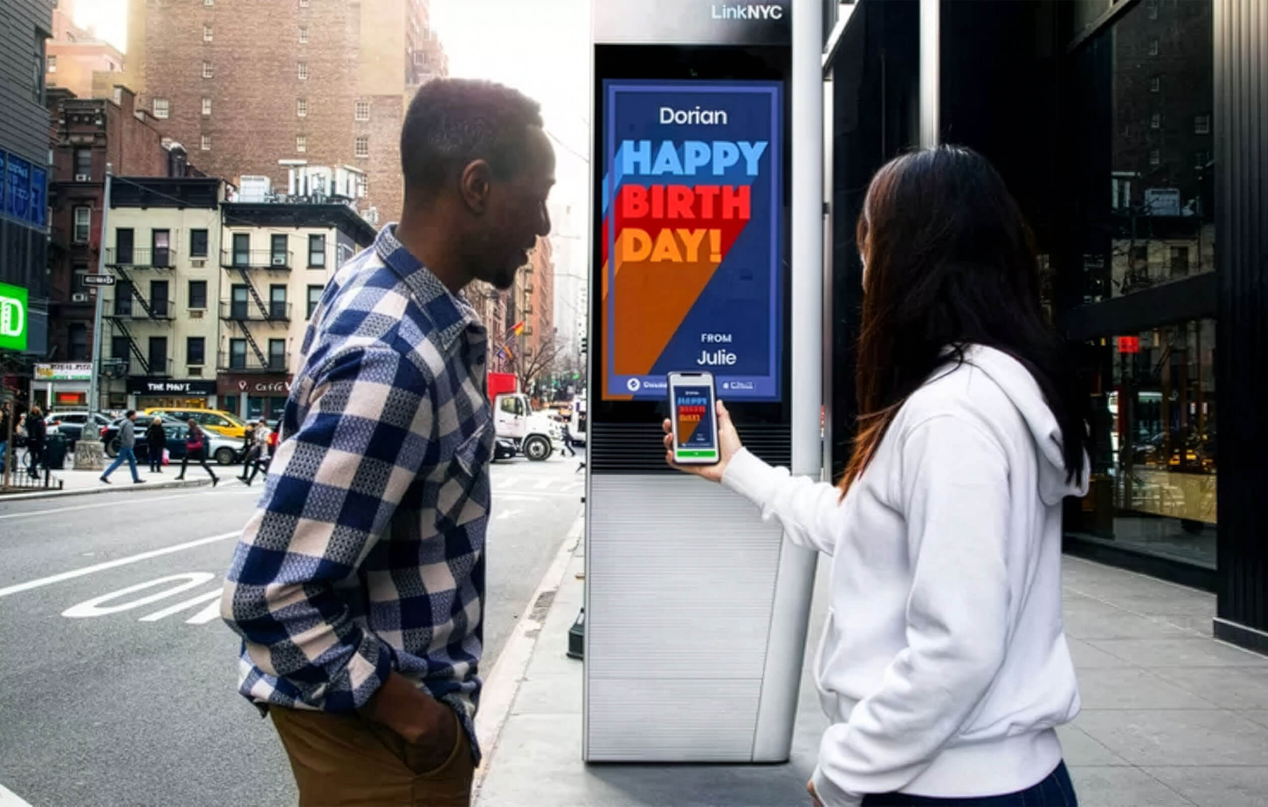 Two people connecting to Wi-Fi next to a LinkNYC kiosk