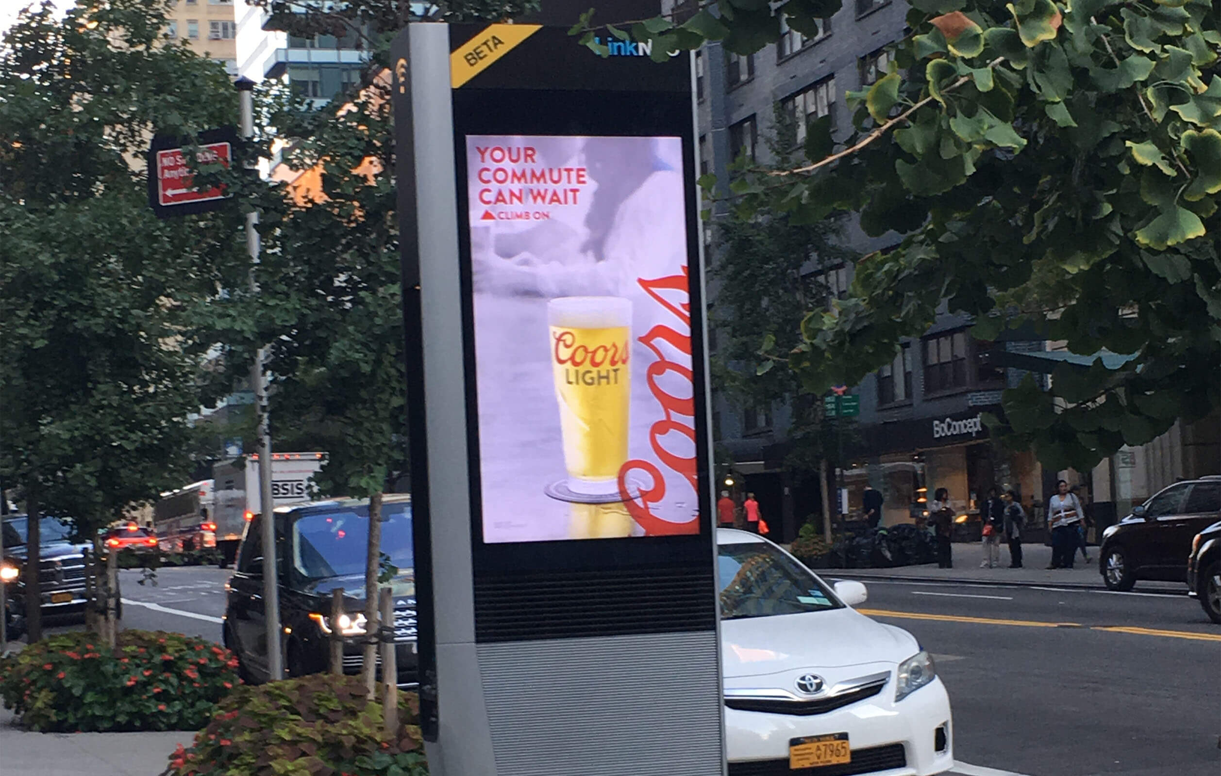 A LinkNYC advertising display on the corner of a street in New York City