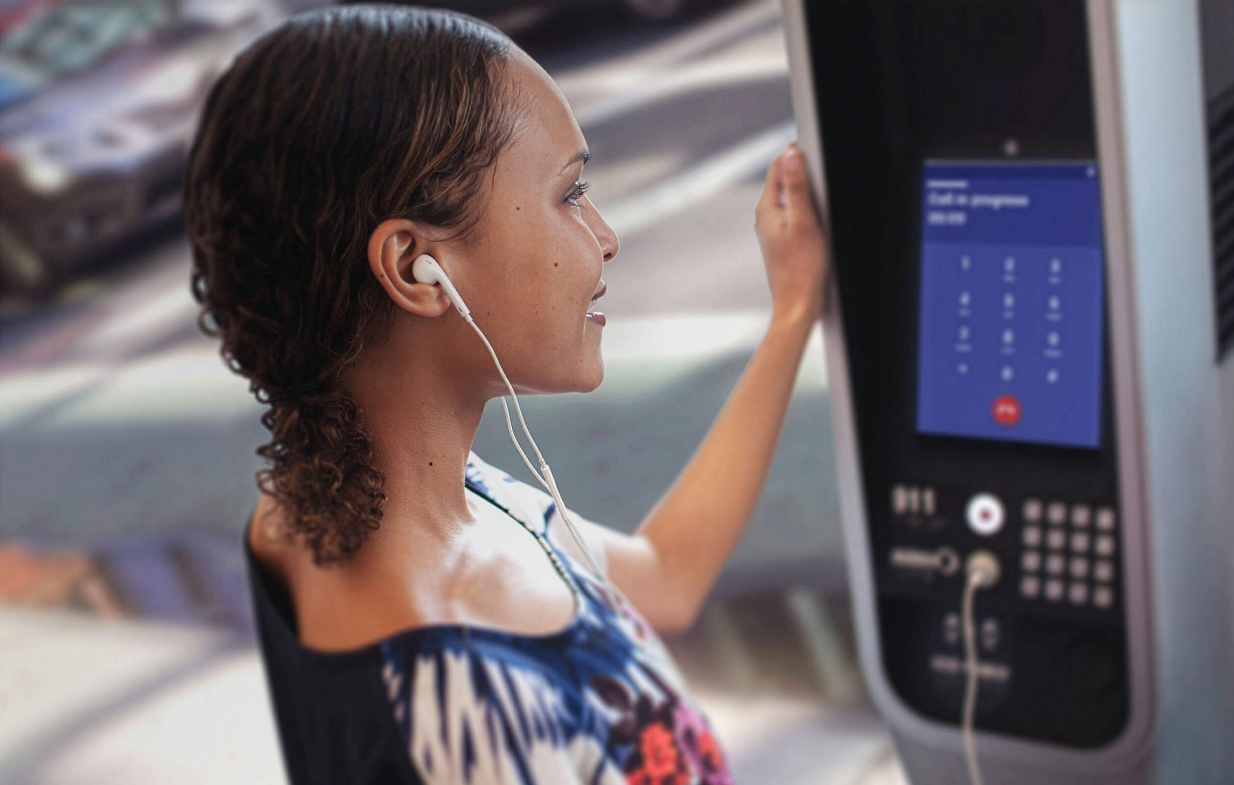 A woman making a phone call on a LinkNYC device