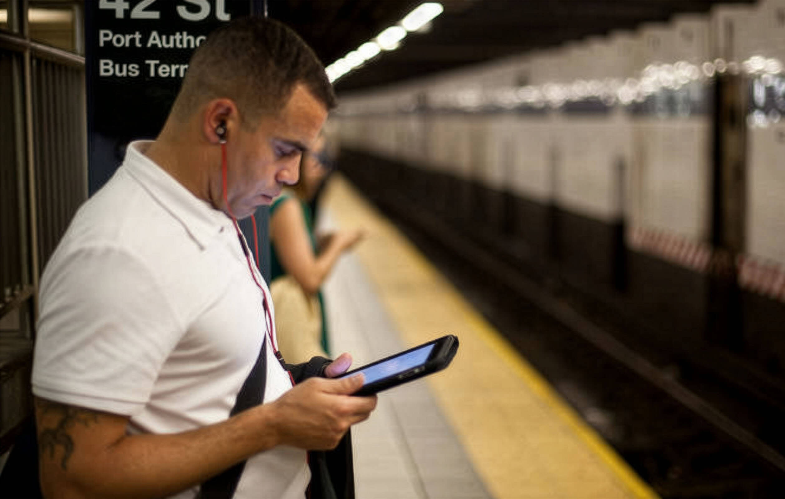 Man looking at his phone in a subway station in New York City