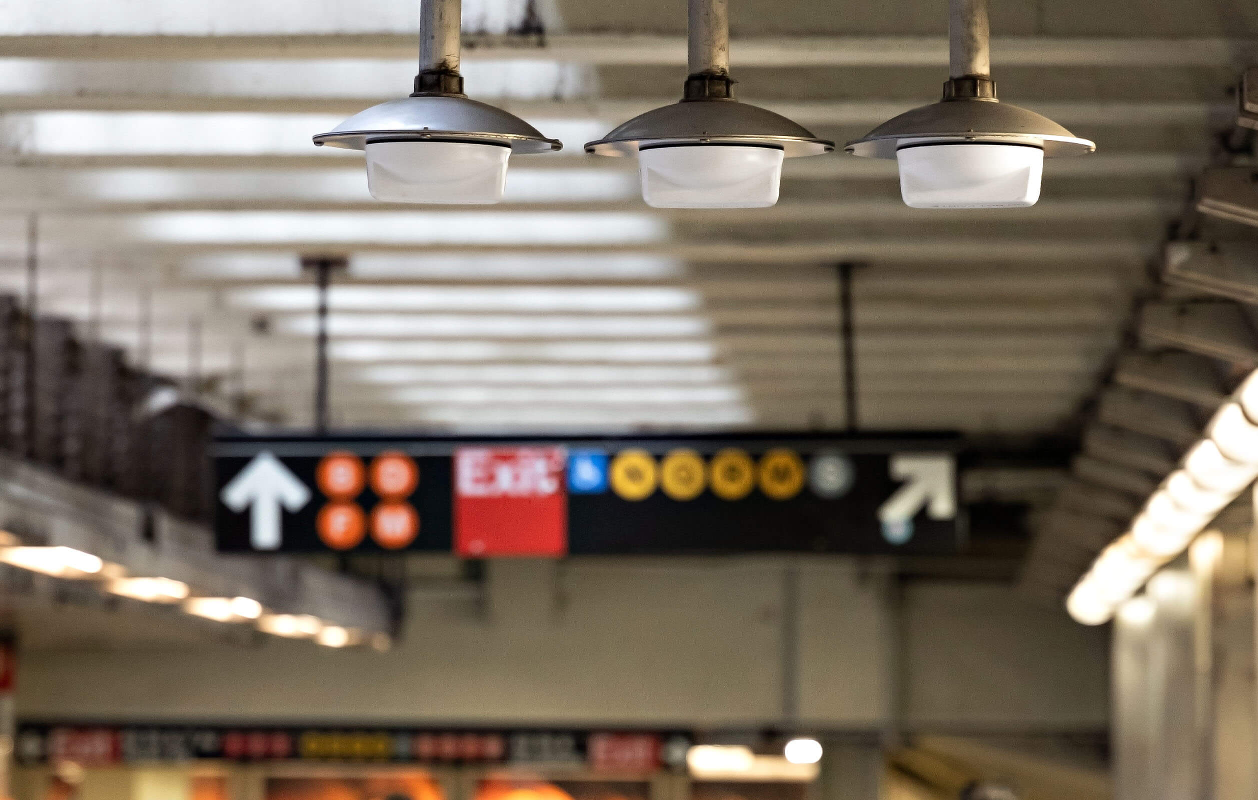 Commuters walking underneath equipment that enables free Wi-Fi connectivity in an underground New York City subway station