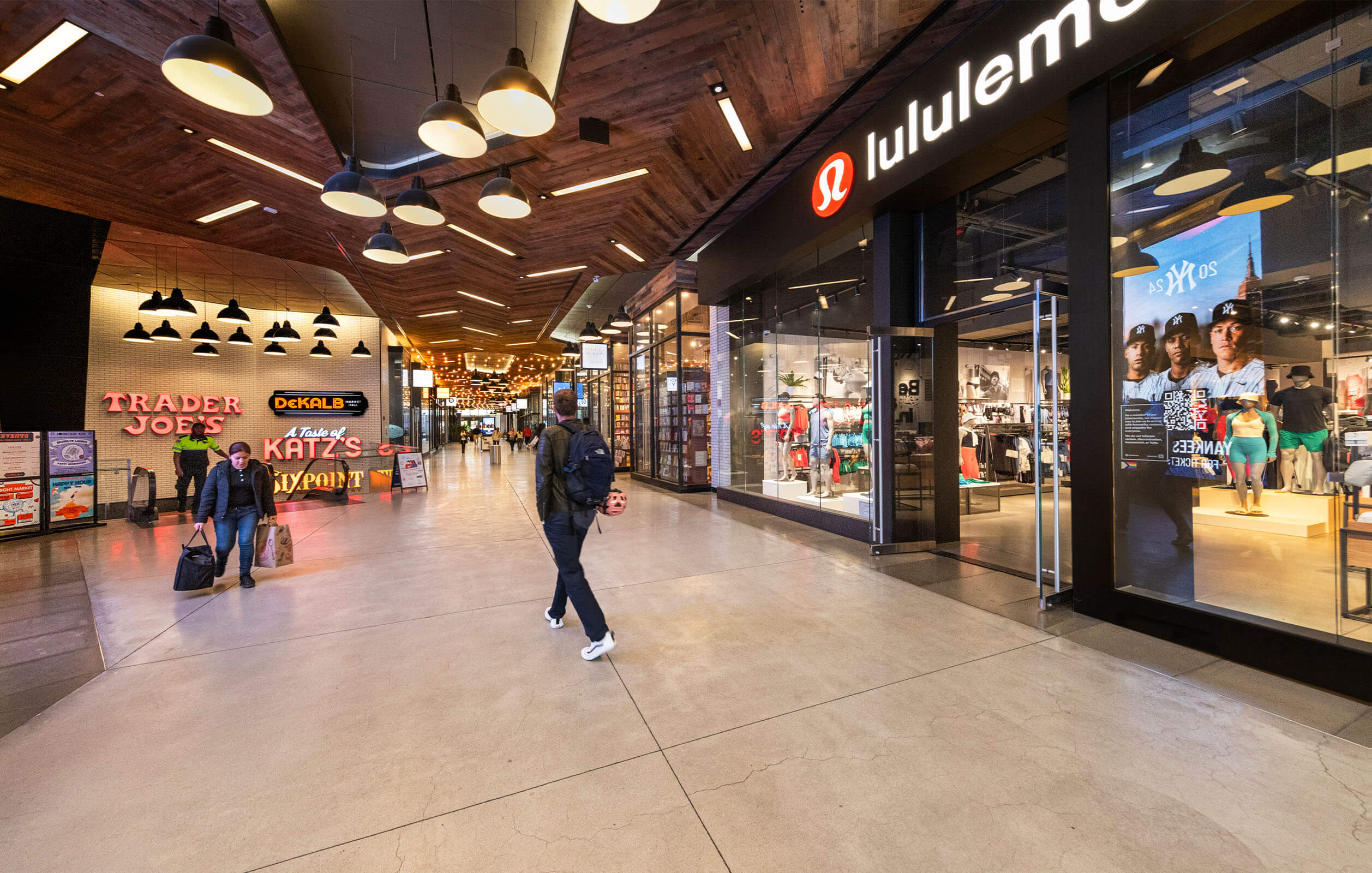 Customers walking past the Lululemon shop and other stores inside City Point